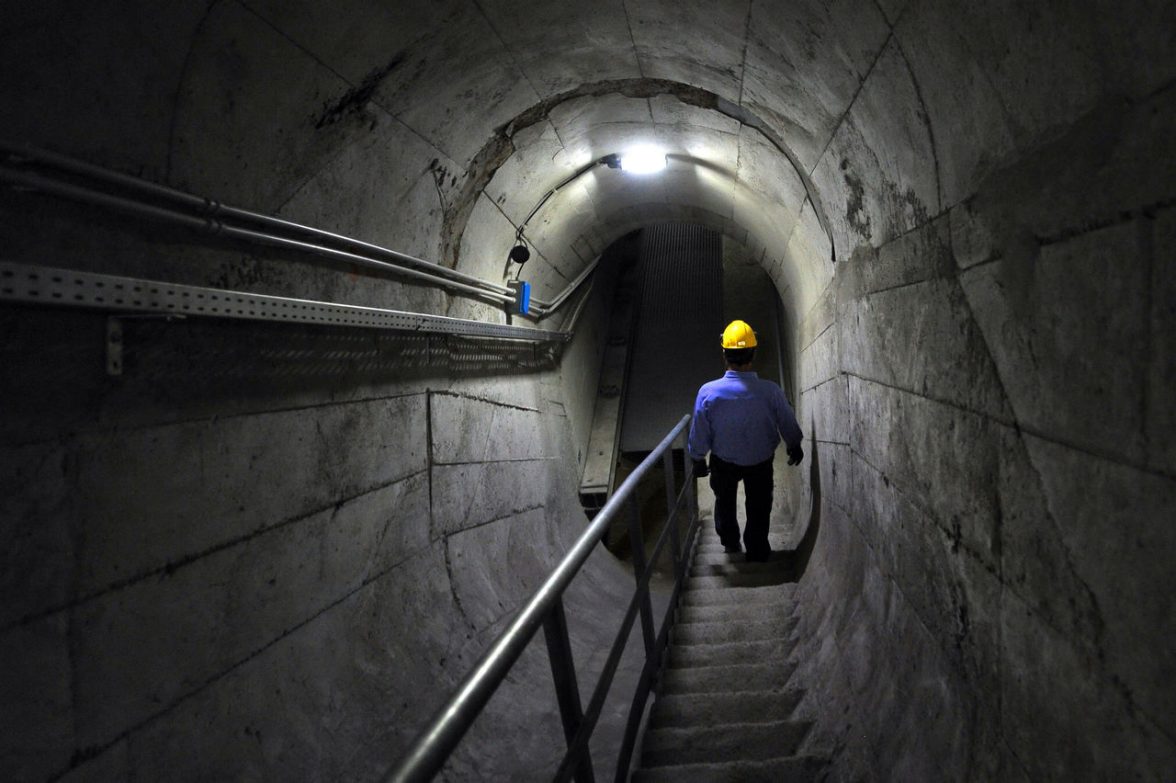 Vista all'interno di un tunnel in cui un dipendente Iren camminata all'interno di una diga 