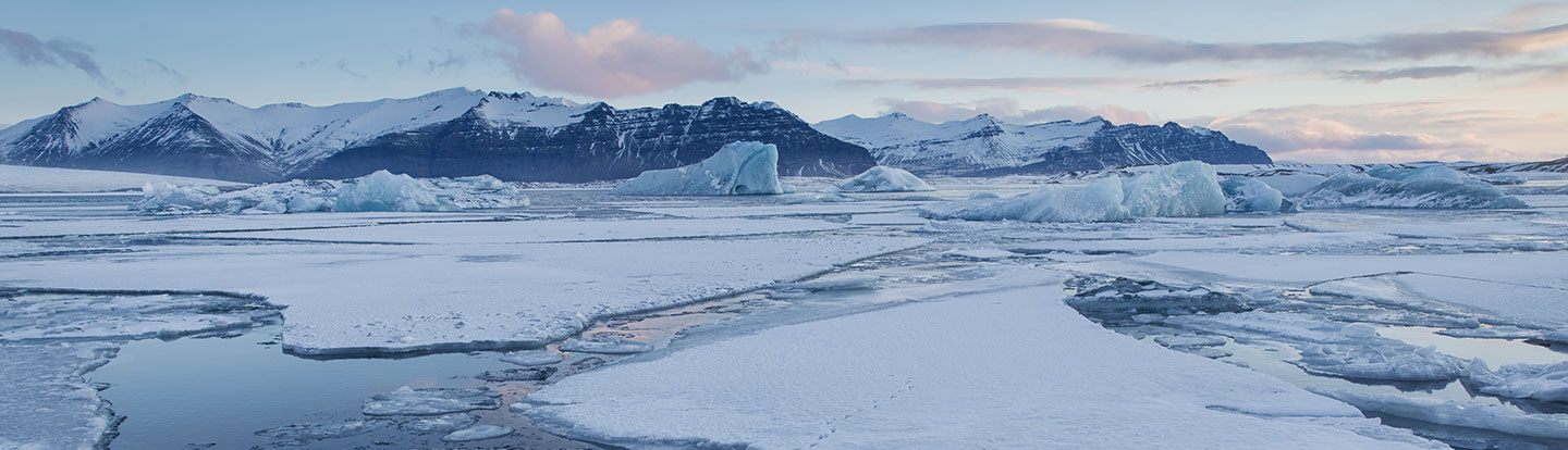 Panorama all’alba sulla laguna di Jökulsárlón in Islanda, con il riflesso della luce sull’acqua tra i blocchi di ghiaccio galleggianti.