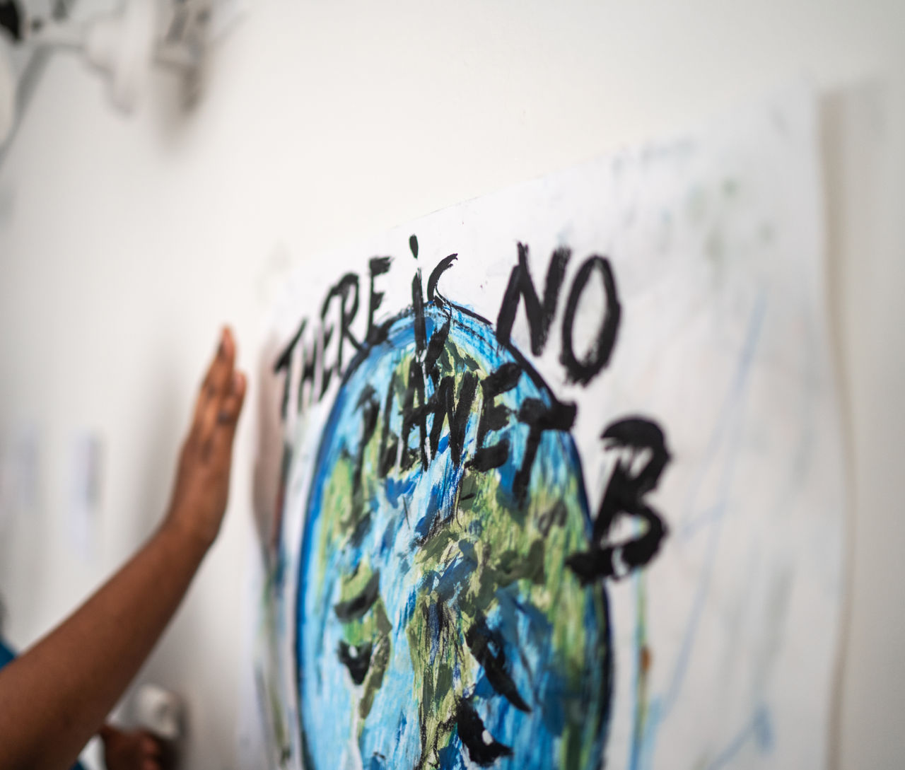 Donna che scrive su un foglio "There is no planet b", con disegno del mondo